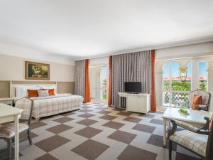 a hotel room with a bed and a tv at Kremlin Palace in Lara