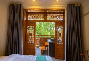 a room with a bed and a door with a window at 青城山泉青小院温泉中式民宿 in Taiping