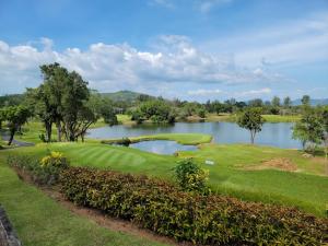 a golf course with a lake in the background at The Urban Tropical Apartments in Mai Khao Beach