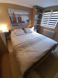 une chambre avec un lit et un tableau au mur dans l'établissement La palmeraie de brévy, à Réville