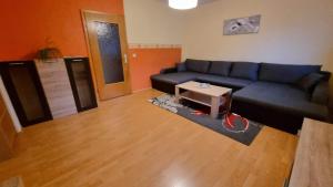 a living room with a blue couch and a table at Ferienwohnungen und Zimmer in Nordhausen in Nordhausen +7 photos