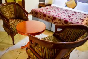 Schlafzimmer mit einem Bett, einem Tisch und Stühlen in der Unterkunft Anthena Hotel in Athi River