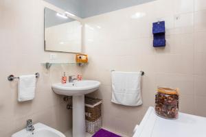 Un baño con lavabo, inodoro y espejo. en Casa Musa Giardini Naxos, en Giardini Naxos 13 fotos más