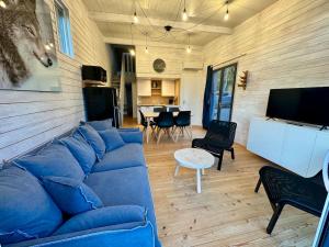 a living room with a blue couch and a tv at Superbe logement 5 personnes Chalet 4 in Banassac
