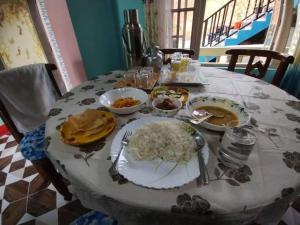 a table with plates of food and rice on it at Gyalsang Homestay in Mirik