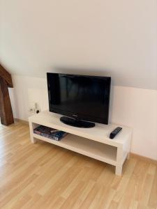 スダンにあるL'écrin des rempartsの白いエンターテイメントセンターに座って薄型テレビを視聴できます。