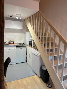 スダンにあるL'écrin des rempartsの白いキャビネットと木製の階段付きのキッチン +13枚の写真