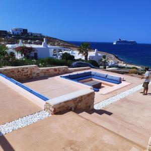 a man standing next to a swimming pool with the ocean at In Paros, fantastic waterfront villa in Parikia +58 photos