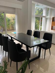 a dining room with a glass table and chairs at Luxury 4BR New Cairo Villa with Pool & Stylish Living - FAMILY ONLY in Cairo +175 photos