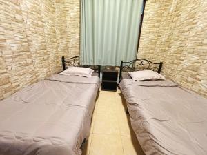 two twin beds in a room with a window at 曼谷市中心大空间6卧室花园泳池别墅 in Bangkok