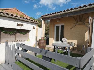 a backyard with a table and a fence at Au soleil couchant in Villemoustaussou