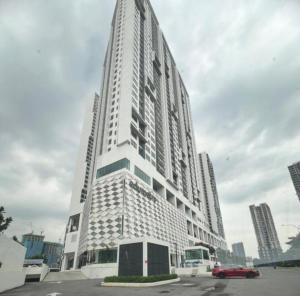 a tall white building with a red car in front of it at Edumetro Subang Permai USJ in Subang Jaya
