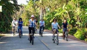 a group of people riding bikes down a road at Chuenwaree Riverside Stay in Suratthani