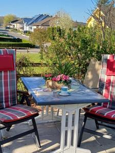 a blue table with two chairs and a bowl of flowers at Ferienwohnung Thielen in Badem