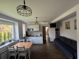 een keuken en woonkamer met een tafel en een bank bij Apartamenty ZATOR20 2 min od Energylandii in Zator
