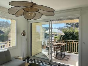 sala de estar con ventilador de techo y mesa con sombrilla en Villa des Braves in Omaha Beach, sea view, en Saint-Laurent-sur-Mer