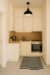 a kitchen with white cabinets and a sink at Maria Plomari Apartments in Plomarion