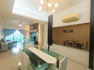 怡保K. Riverfront apartment的配有玻璃桌和白色椅子的餐厅