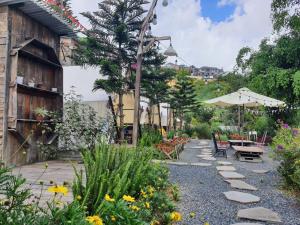 a garden with a table and chairs and flowers at Dalana Coffee Camping Đà Lạt in Da Lat