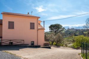 a large pink house with a fence next to it at Poggio di Cammilletto in Montefiascone
