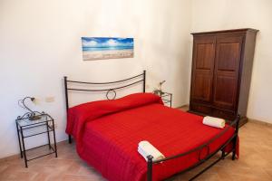 a bedroom with a red bed and a wooden cabinet at Poggio di Cammilletto in Montefiascone