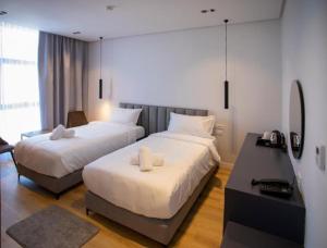 a hotel room with two beds and a desk at Resort Zdrava in Savër