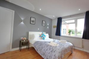 a bedroom with a bed and a window at Stunning 3 Bedroom 2 Bathroom Bungalow by CozyNest in Earley