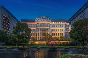 上海Shanghai Hongqiao Hub Minbei Road Orange Crystal Hotel的一座前面有池塘的大型办公楼