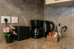 a kitchen counter with two black coffeemakers on a counter at Blue Harbour Seafront 3 bedroom apartment, with spectacular sea views from terrace - by Getawaysmalta in St. Paul's Bay +17 photos