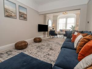 ein Wohnzimmer mit einer blauen Couch und einem Fernseher in der Unterkunft Coral Villa in Bridlington
