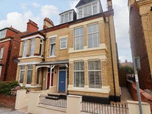 ein großes Backsteinhaus mit einer blauen Tür in der Unterkunft Coral Villa in Bridlington