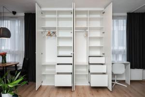 a room with white shelves and a desk at Bastion New Apartment with Parking in Košice +31 photos