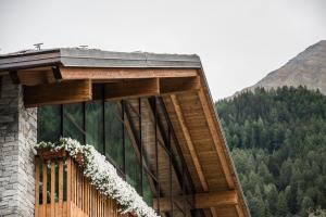 budynek z balkonem pokrytym kwiatami w obiekcie Grand Hotel Courmayeur Mont Blanc, by R Collection Hotels w mieście Courmayeur +37 zdjęć