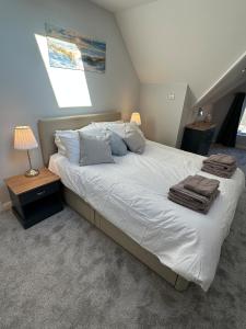 a bedroom with a large bed with white sheets and pillows at Luxury, Tranquillity Near Beach in Carbis Bay
