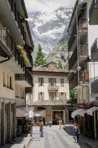 ulica z budynkami i góra w tle w obiekcie Grand Hotel Courmayeur Mont Blanc, by R Collection Hotels w mieście Courmayeur