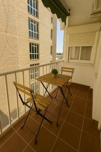 a balcony with a wooden table and two chairs at Acogedor apartamento recién reformado en el puerto deportivo de Aguadulce in Aguadulce +4 photos