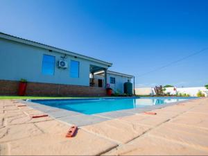 a swimming pool in front of a house at Salush Guest House in Mtubatuba