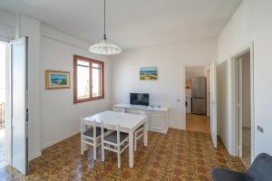 a dining room with a white table and a desk at Mati in Poesia - San Foca in Melendugno