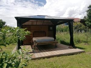 a bed in a gazebo on a deck at Belle villa in Bourg-de-Péage