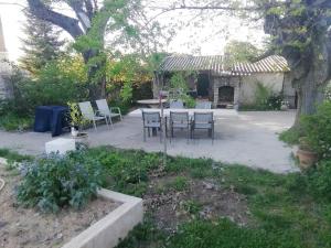 a patio with a table and chairs in a yard at Belle villa in Bourg-de-Péage