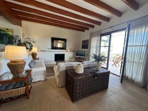 a living room with white furniture and a large window at Villa Golf D'or in Portocolom