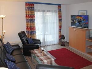 - un salon avec 2 fauteuils en cuir et une télévision dans l'établissement Ferienhaus Nr 28, Kategorie Königscard, Feriendorf Hochbergle, Allgäu, à Lechbruck am See