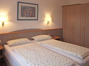 - 2 lits dans une chambre avec 2 lampes murales dans l'établissement Ferienhaus Nr 28, Kategorie Königscard, Feriendorf Hochbergle, Allgäu, à Lechbruck am See