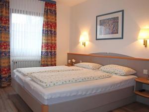 une chambre avec un grand lit avec deux oreillers dans l'établissement Ferienhaus Nr 28, Kategorie Königscard, Feriendorf Hochbergle, Allgäu, à Lechbruck am See 10 autres photos