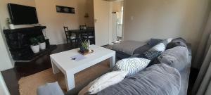 una sala de estar con un sofá y una mesa en Peaceful Apartment - getaway to the countryside, en Meyerton