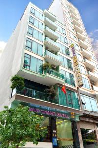 a tall white building with a pharmacy in front of it at Đức Thắng Hotel in Sầm Sơn