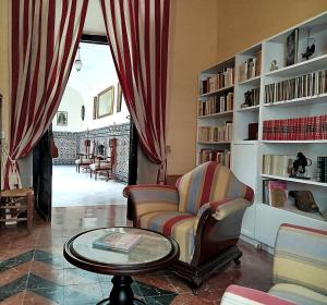 a living room with a chair and a table at Casa Palacio Domus Astigi in Écija