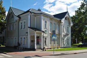 un grand bâtiment blanc avec un toit en gambrel dans l'établissement Dalija, à Druskininkai