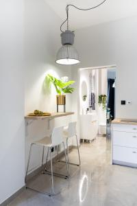 a kitchen with white chairs and a table with a plant at Studio LOFT12 in Kielce