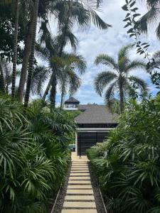 un sentiero che conduce a una casa con palme di Secret Garden at Bangtao Beach a Surin Beach